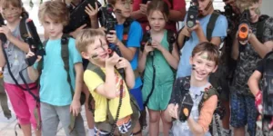Group of children in camouflage with toy guns, posing for laser tag