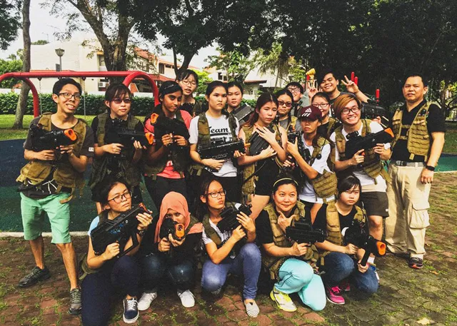 Group of people in tactical vests holding toy guns at a playground