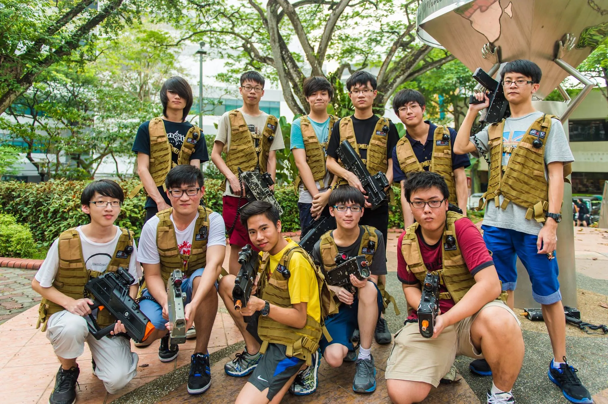 Group of young individuals in tactical vests holding toy guns outdoors